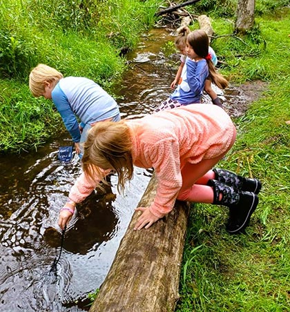 Kids investigating a rippling creek.